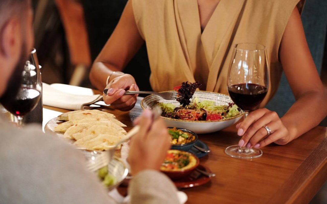 Couple having a romantic Italian dinner date with glasses of wine.