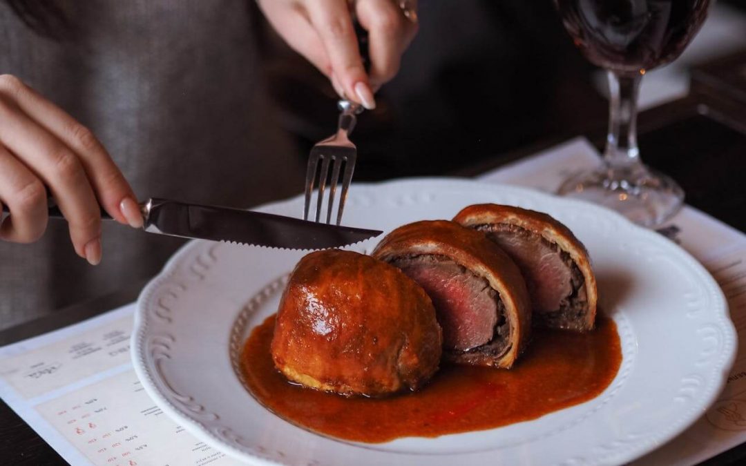 Person cutting a beef wellington